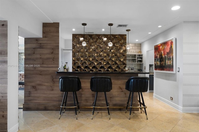 bar featuring recessed lighting, visible vents, baseboards, a bar, and pendant lighting