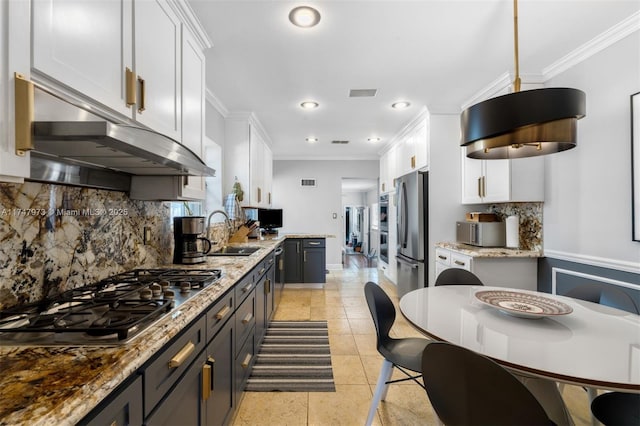 kitchen with stainless steel appliances, a sink, white cabinets, gray cabinets, and decorative light fixtures