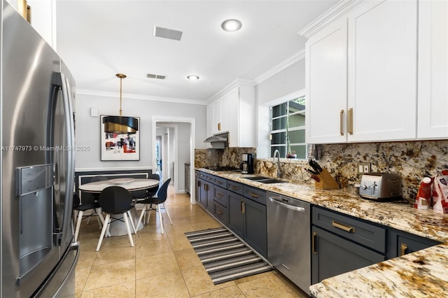 kitchen with white cabinets, pendant lighting, stainless steel appliances, and a sink