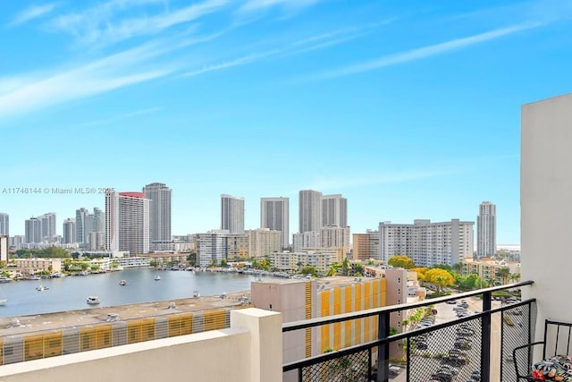 balcony with a water view and a view of city