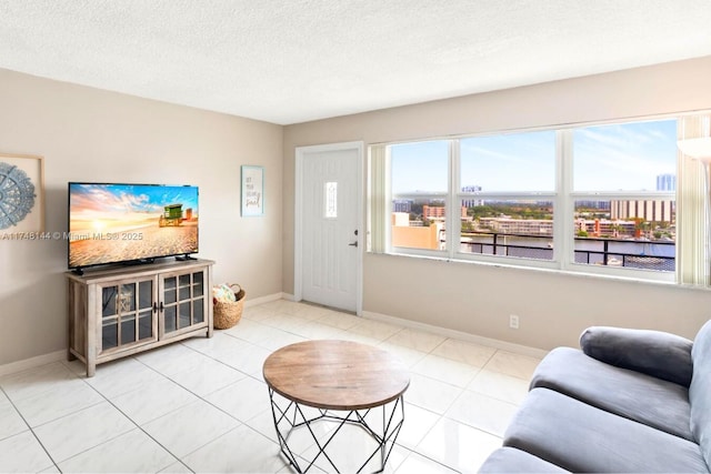 living area with a city view, tile patterned flooring, baseboards, and a textured ceiling