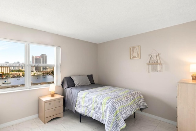 bedroom featuring baseboards and a city view