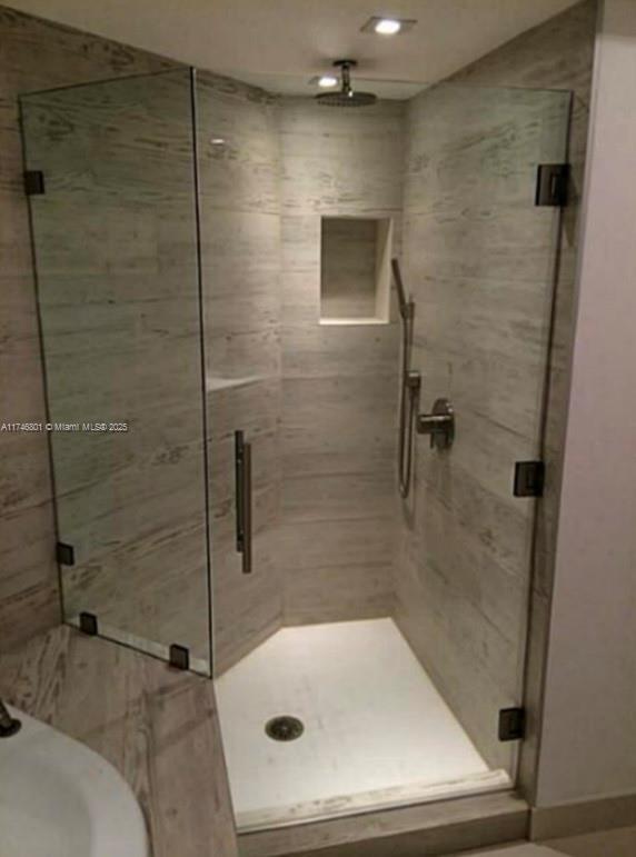 bathroom with a stall shower and a sink