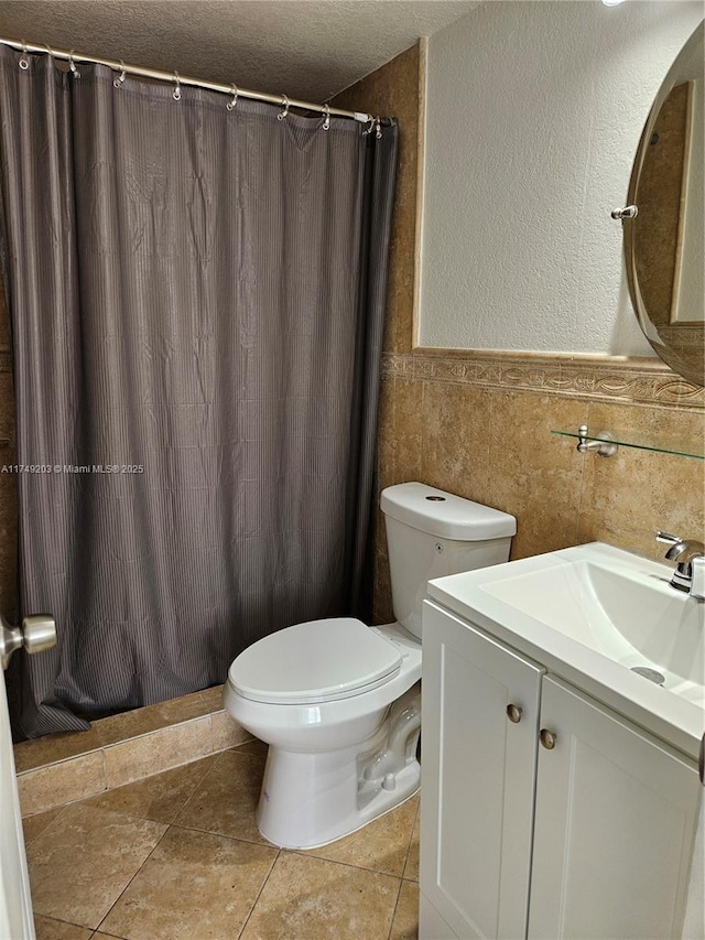 bathroom with tile patterned flooring, toilet, tile walls, vanity, and a shower with curtain