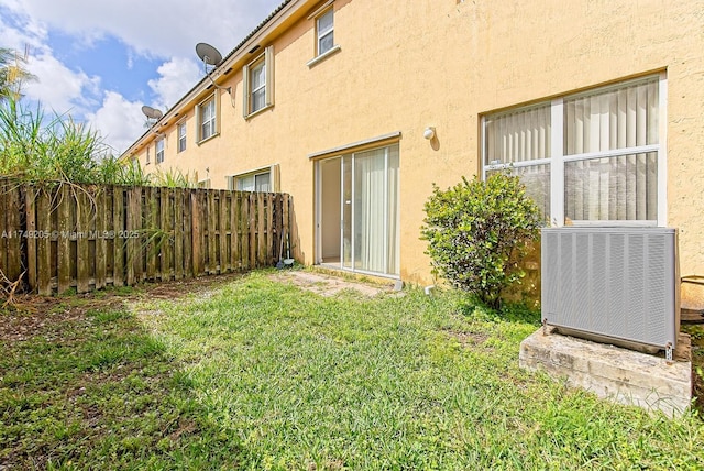view of yard with central AC and fence