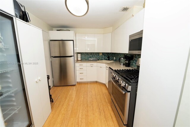 2030 S Ocean Dr Unit 618, Hallandale Beach, FL 33009 - kitchen featuring stainless steel appliances, white cabinetry, light wood-style floors, light countertops, and decorative backsplash