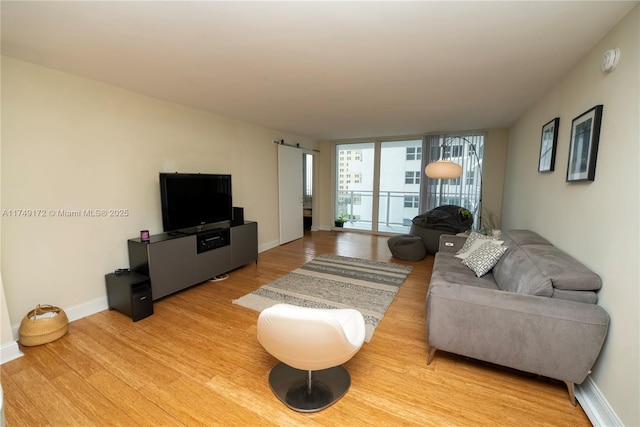 2030 S Ocean Dr Unit 618, Hallandale Beach, FL 33009 - living room with light wood-type flooring, a barn door, expansive windows, and baseboards