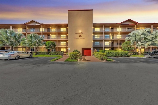 property at dusk featuring uncovered parking