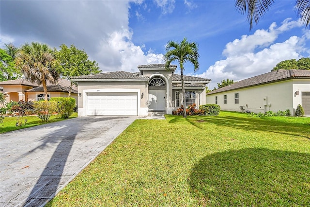 mediterranean / spanish home featuring stucco siding, an attached garage, a front yard, driveway, and a tiled roof