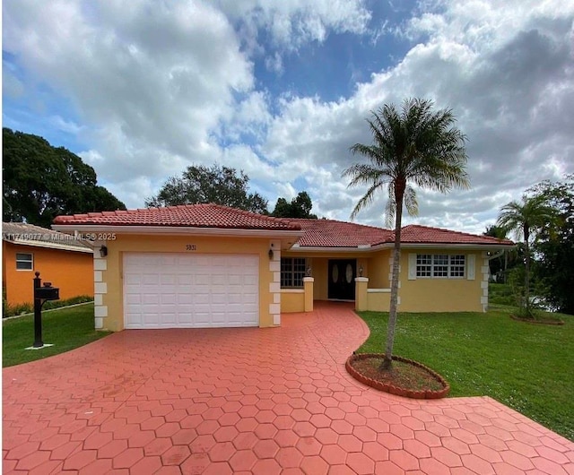 ranch-style house featuring decorative driveway, a tile roof, stucco siding, a garage, and a front lawn