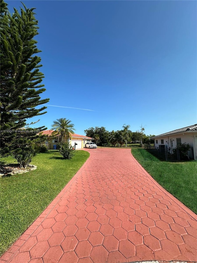 surrounding community with a garage, a lawn, and driveway