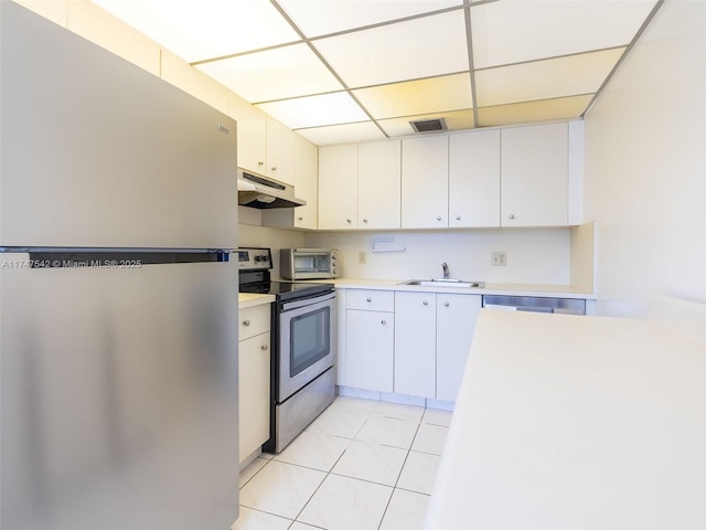 kitchen featuring appliances with stainless steel finishes, light countertops, under cabinet range hood, white cabinetry, and a sink