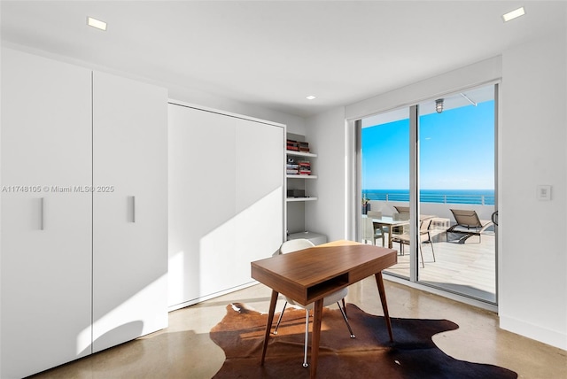 office with a water view, concrete floors, and recessed lighting