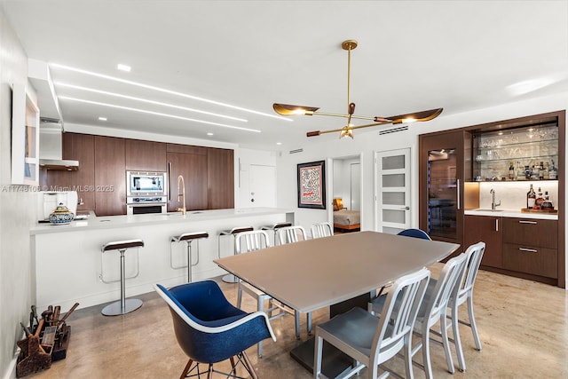 dining room featuring concrete flooring and indoor wet bar