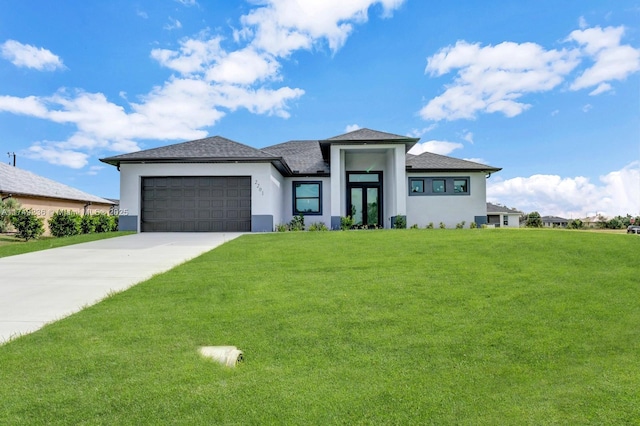 prairie-style home with a garage, a front lawn, concrete driveway, and stucco siding