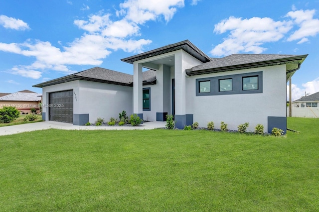 prairie-style house featuring a garage, a front yard, concrete driveway, and stucco siding