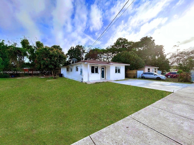 single story home featuring a front lawn, driveway, and fence