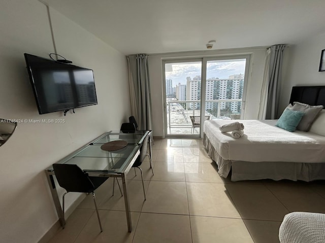 bedroom featuring access to exterior, a city view, and light tile patterned floors