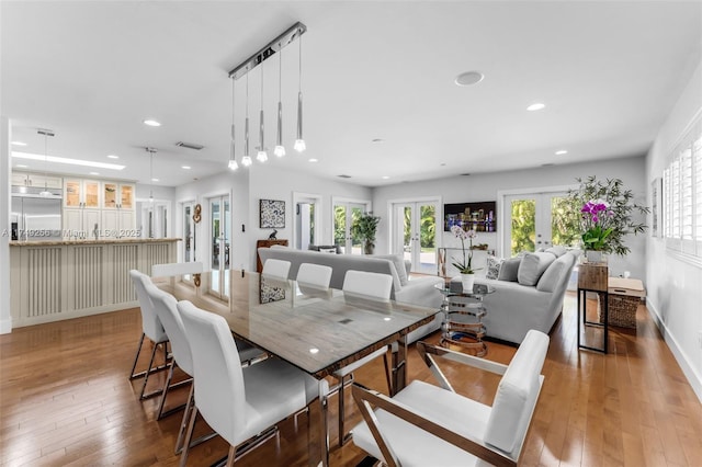 dining space featuring recessed lighting, visible vents, wood finished floors, and french doors