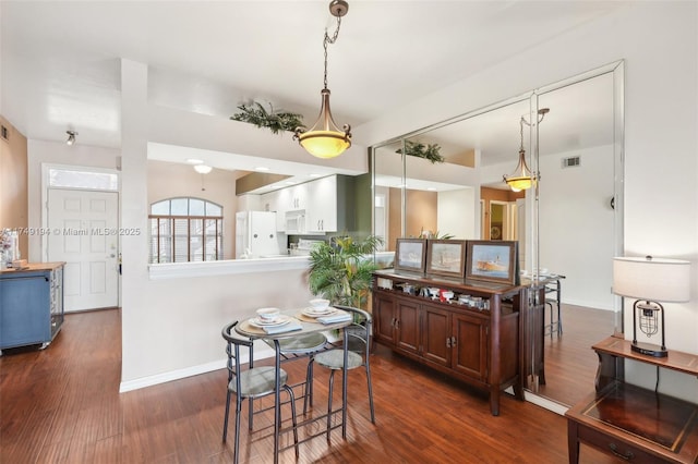 kitchen featuring dark wood-style floors, white appliances, visible vents, and baseboards