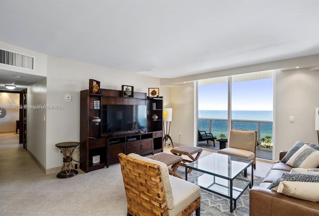 living room featuring baseboards, visible vents, and a wall of windows