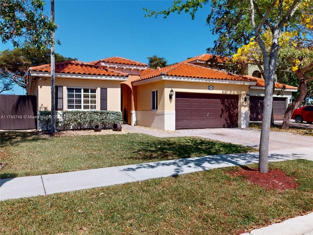 mediterranean / spanish-style home with a garage, driveway, stucco siding, a tile roof, and a front yard