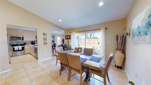 dining space with lofted ceiling, light tile patterned flooring, and baseboards