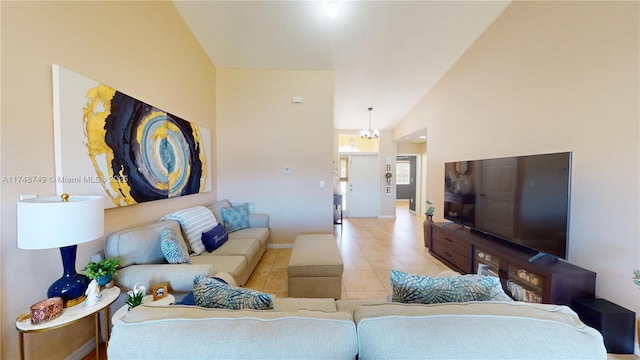 tiled living room with a chandelier, high vaulted ceiling, and baseboards