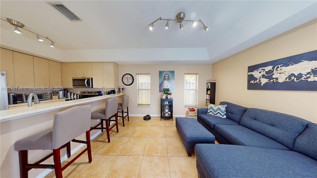 living area featuring light tile patterned floors, baseboards, and visible vents