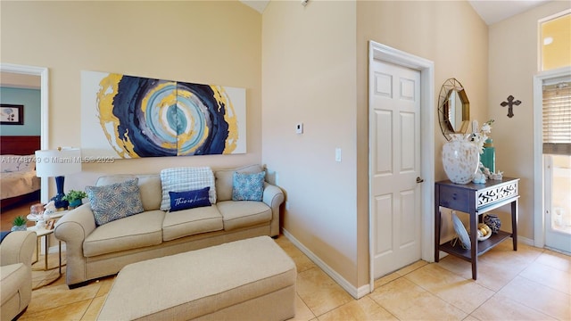 living area featuring light tile patterned flooring and baseboards