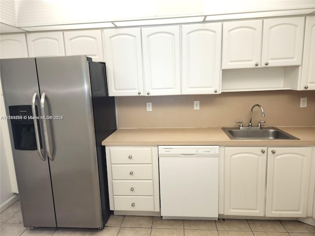 kitchen with light countertops, stainless steel fridge, dishwasher, and a sink