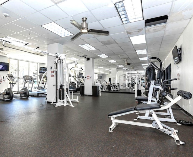 workout area with a paneled ceiling and ceiling fan