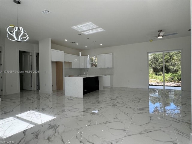 kitchen with marble finish floor, pendant lighting, white cabinets, and light countertops