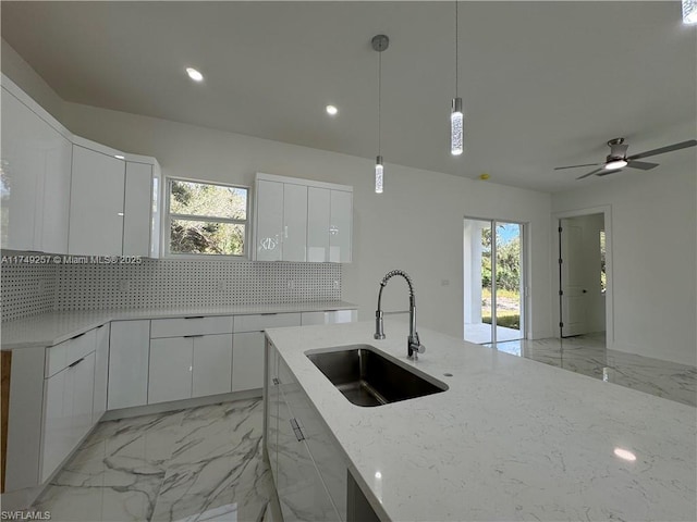 kitchen featuring modern cabinets, white cabinetry, and a sink