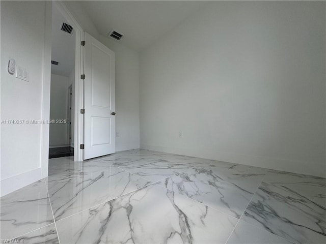 unfurnished room with marble finish floor, visible vents, and baseboards