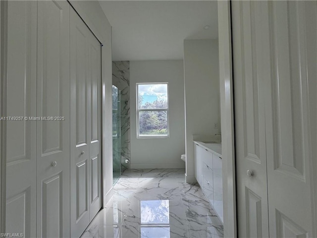 full bath with marble finish floor, a closet, vanity, and toilet