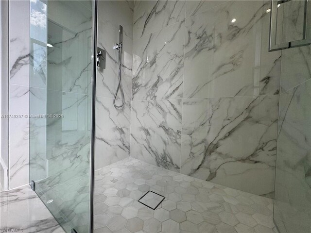 bathroom featuring a marble finish shower