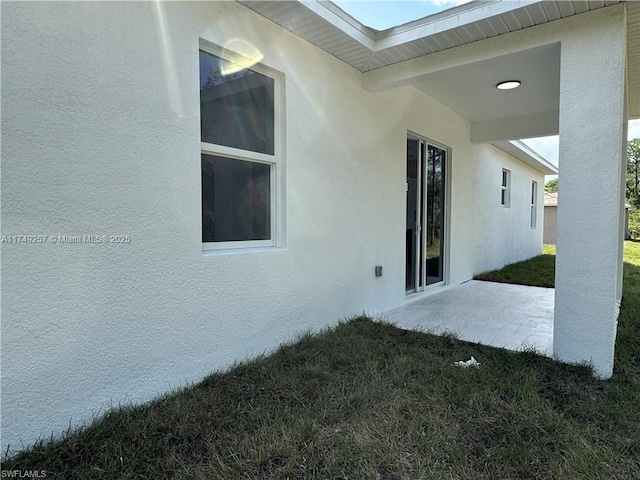 view of home's exterior featuring a patio, a yard, and stucco siding