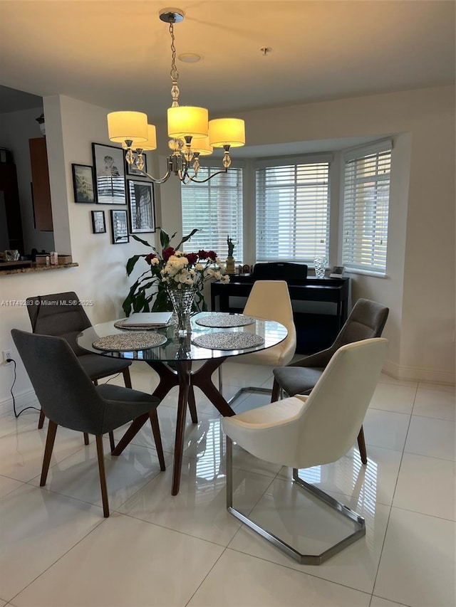 dining area featuring baseboards, an inviting chandelier, and light tile patterned floors