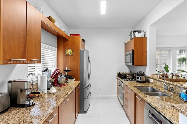 18408 NE 27th Ct Unit 18408, Aventura, FL 33160 - kitchen featuring stainless steel appliances, brown cabinets, light stone countertops, and light tile patterned floors
