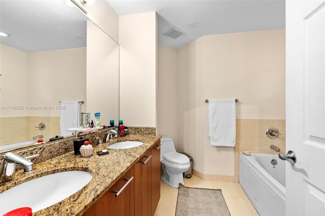 bathroom featuring tile patterned flooring, a garden tub, visible vents, and a sink