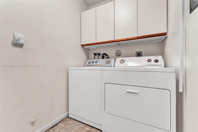 laundry area featuring cabinet space, washer and clothes dryer, and baseboards