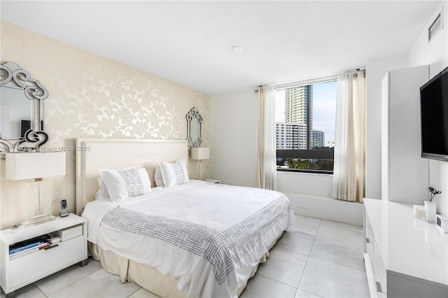 bedroom featuring light tile patterned floors, visible vents, and wallpapered walls