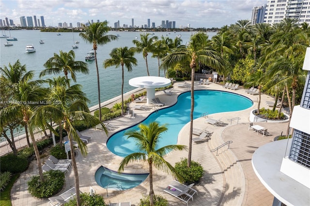 community pool featuring a hot tub, fence, a city view, and a patio