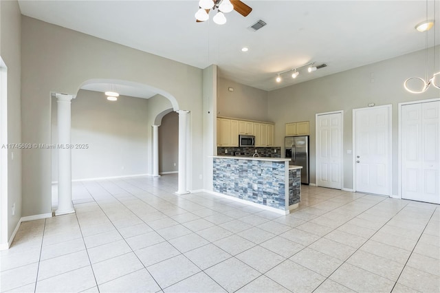 kitchen with arched walkways, appliances with stainless steel finishes, light tile patterned flooring, and visible vents