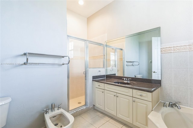 bathroom with a stall shower, toilet, tile patterned floors, vanity, and a bidet