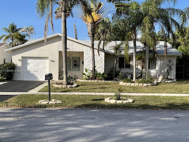 view of front of home featuring aphalt driveway, stucco siding, an attached garage, and a front yard