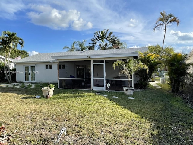 back of property featuring a sunroom, a lawn, french doors, and stucco siding