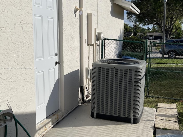 details with fence, central AC, and stucco siding