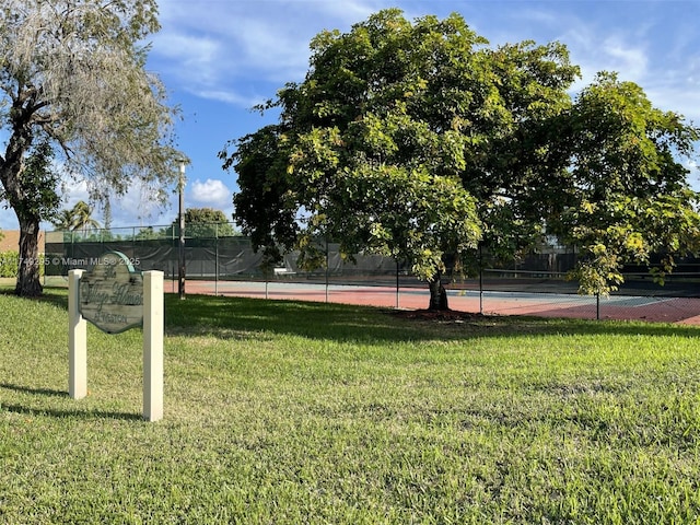 view of community with a lawn and fence